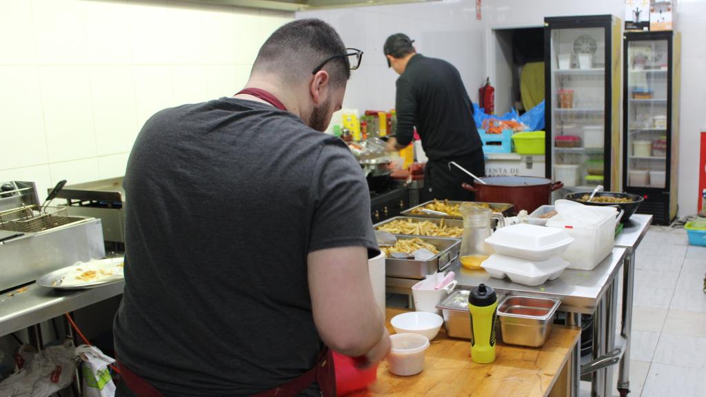 Dos trabajadores de La Grotte, preparando los menús del día.