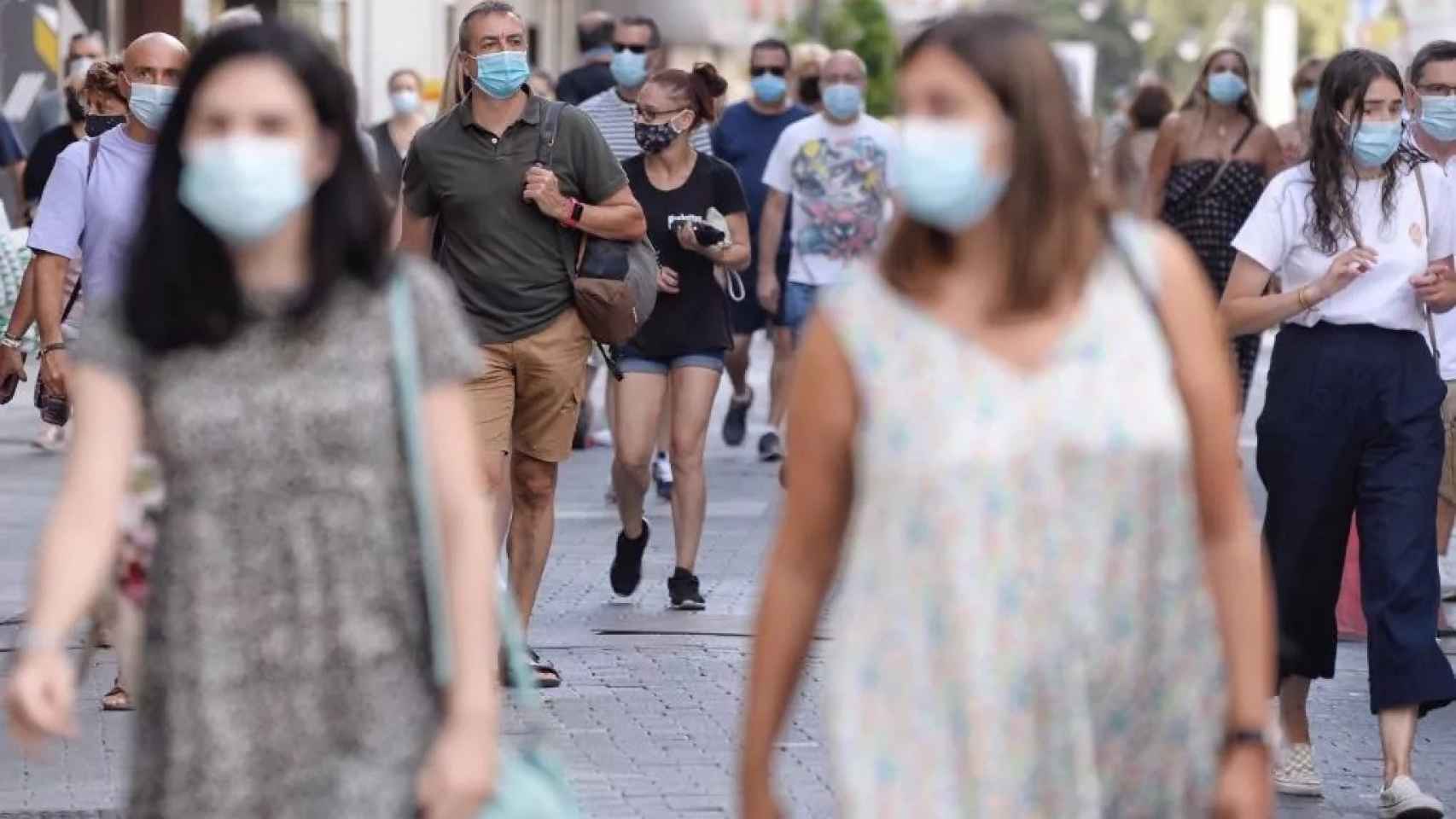 Varias personas por la calle con mascarilla durante la pandemia.