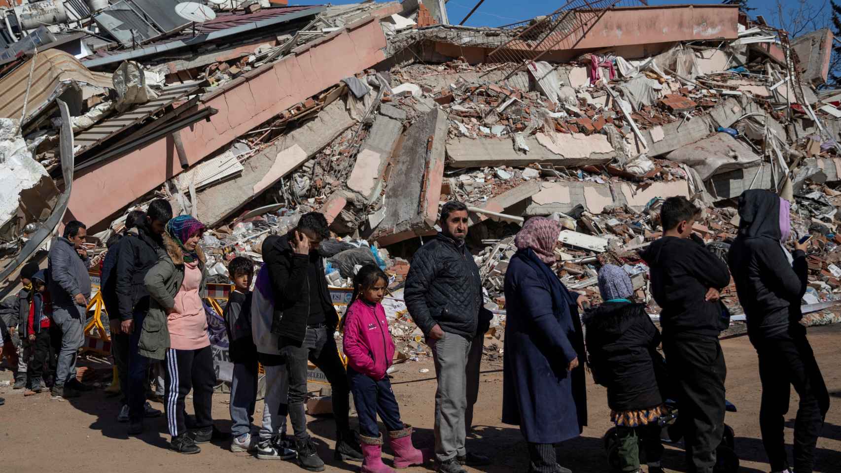 Personas hacen cola para recibir comida gratuita servida entre los escombros tras el mortífero terremoto de Kahramanmaras.