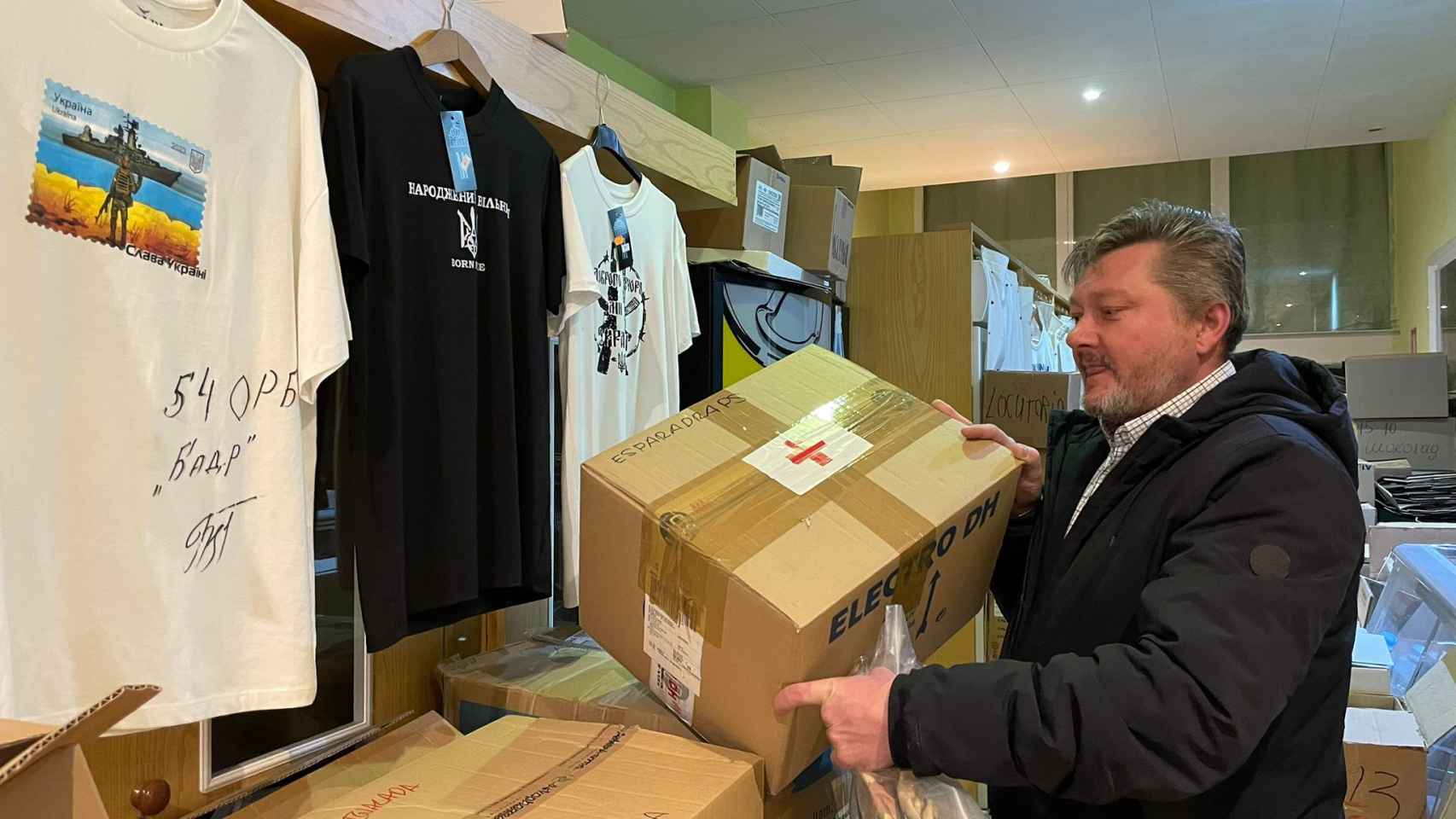 Grynkiv con cajas de ayuda humanitaria entre objetos de 'merchandising' que vende en el locutorio que regenta en Guissona.