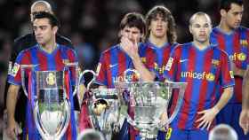 Xavi Hernández, Leo Messi y Andrés Iniesta posan detrás del triplete de títulos conseguido por el Barça de Guardiola en 2009.