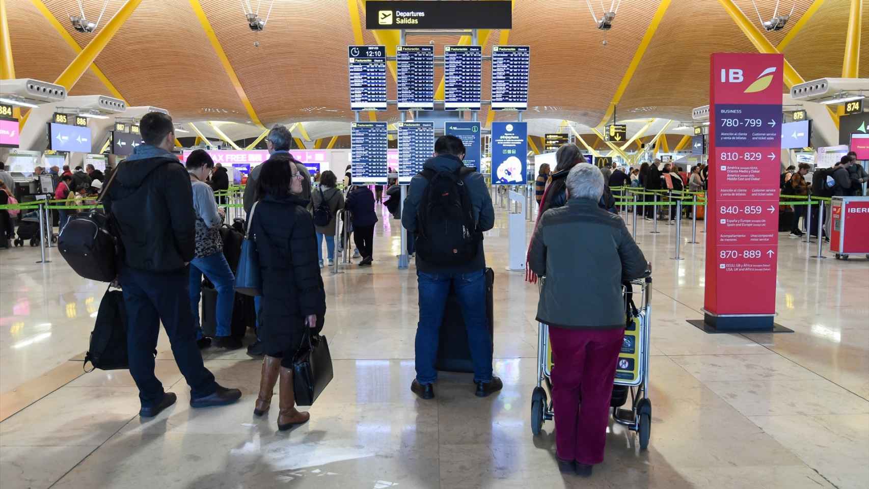 Varias personas aguardan a embarcar en la terminal 4 de Madrid-Barajas