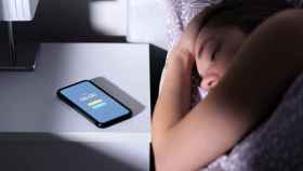 Una persona duerme junto a su teléfono móvil en una imagen de archivo.