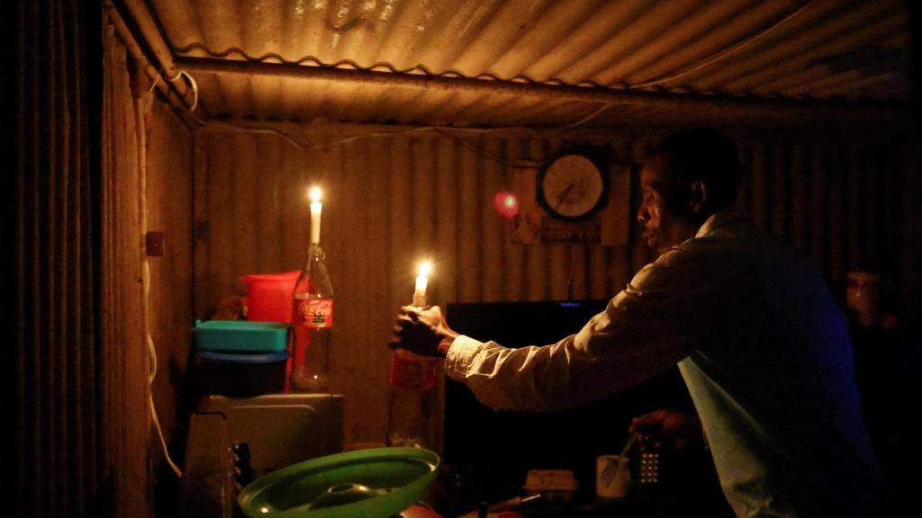 Sparks Ngwenya coloca las velas que utiliza para iluminar su choza.