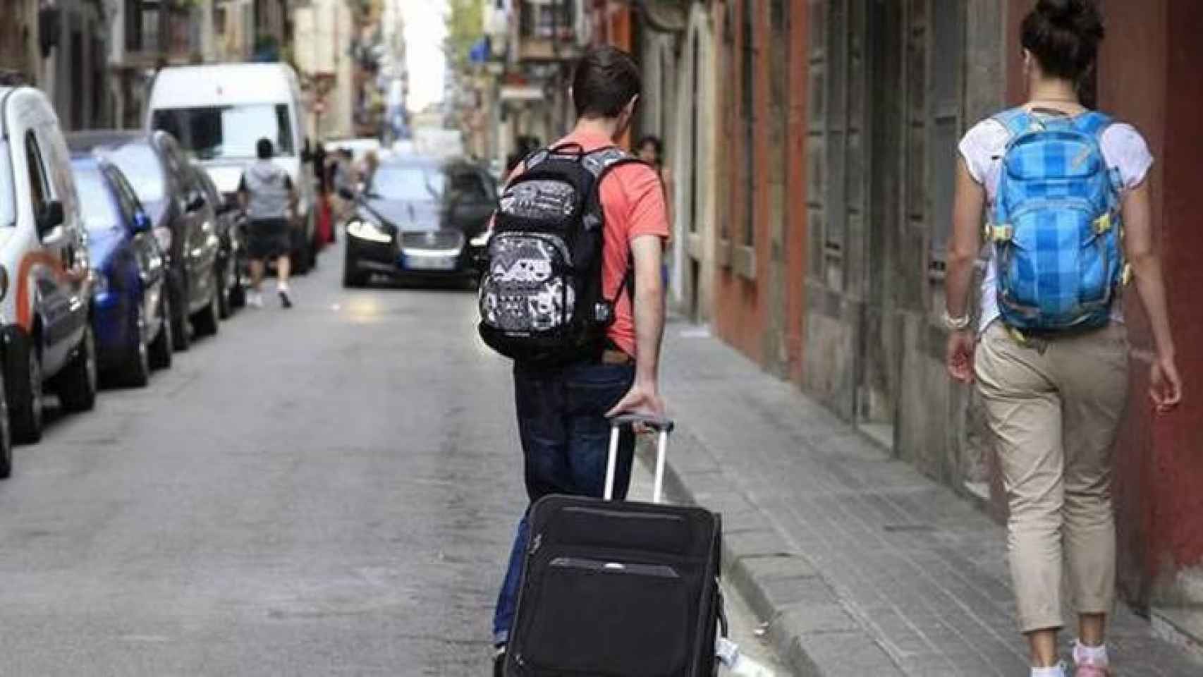 Dos jóvenes con una maleta.