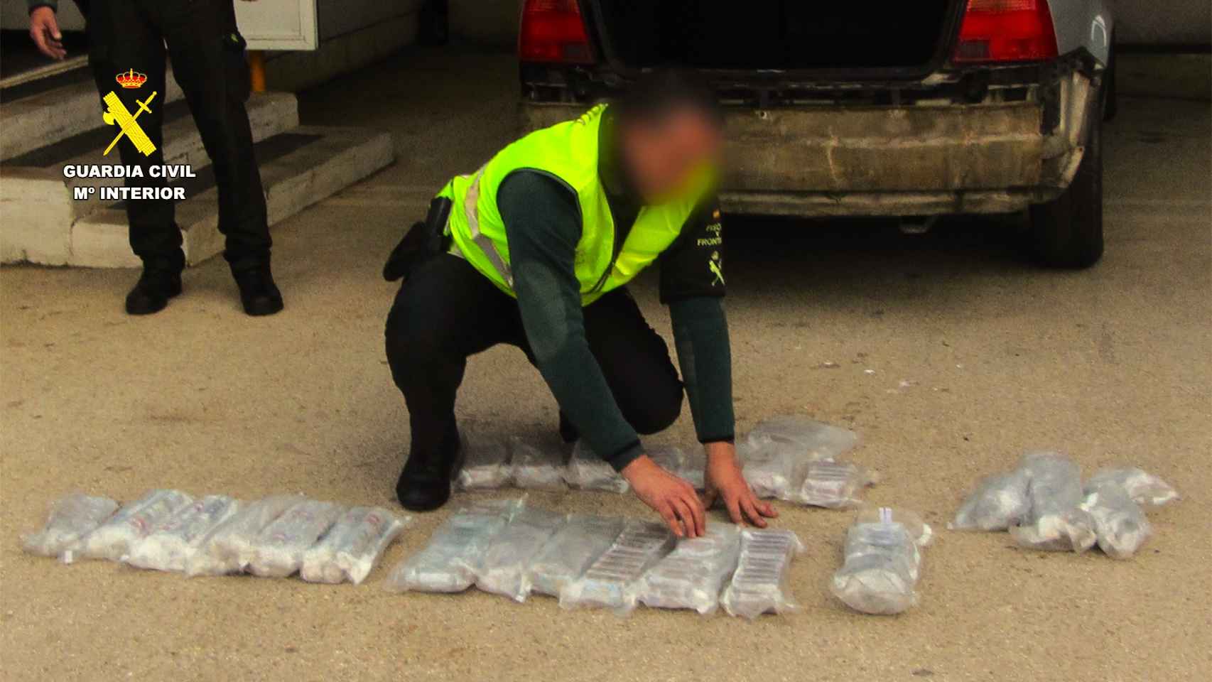 Un agente de la Guardia Civil expone los paquetes encontrados en el turismo en Dénia.