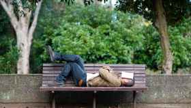 Un hombre duerme una siesta en el parque.