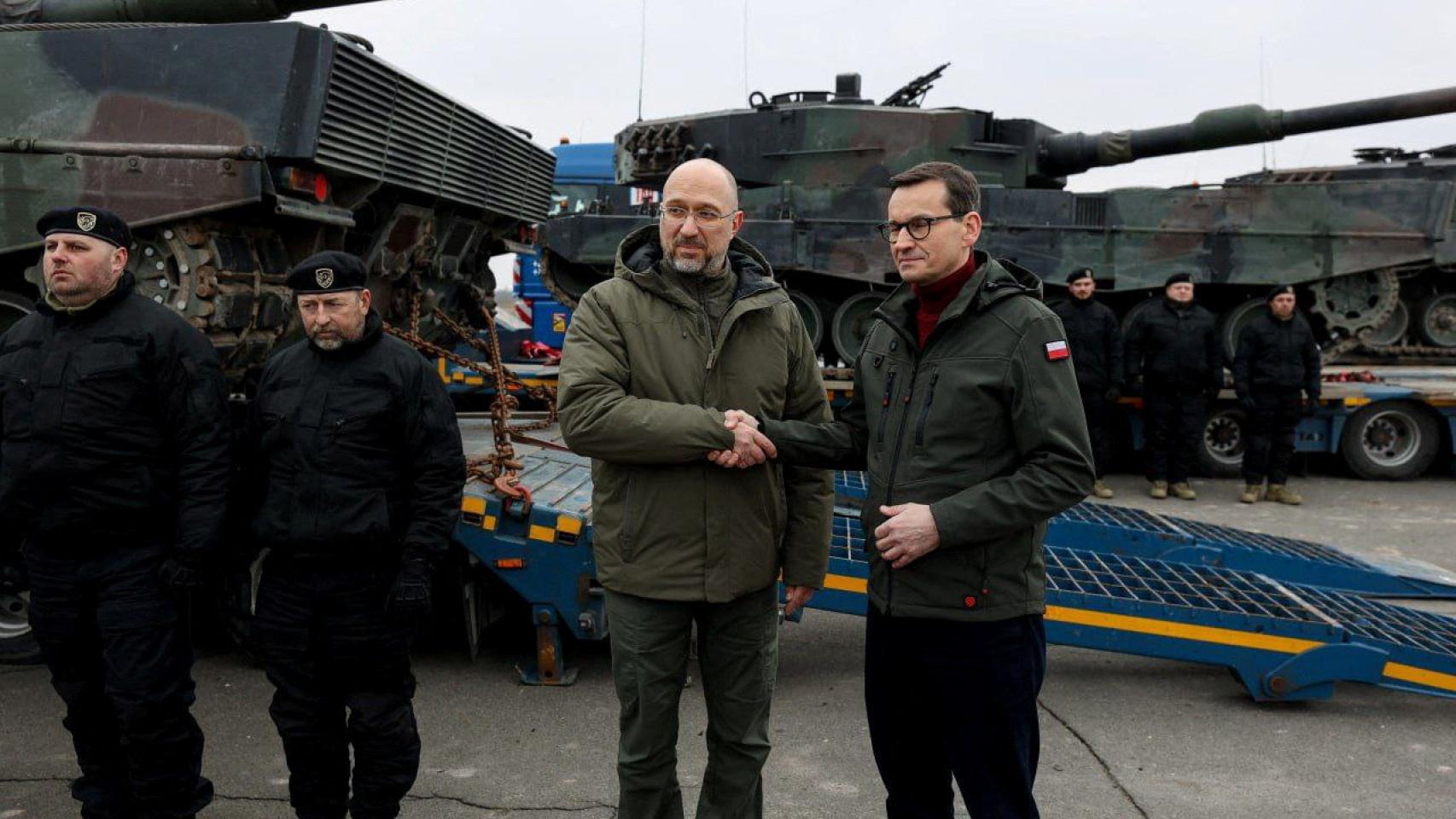 A la derecha, el primer ministro polco, Mateusz Morawiecki, estrechando la mano del primer ministro ucraniano, Denys Shmyhal, junto a los primeros tanques Leopard 2.
