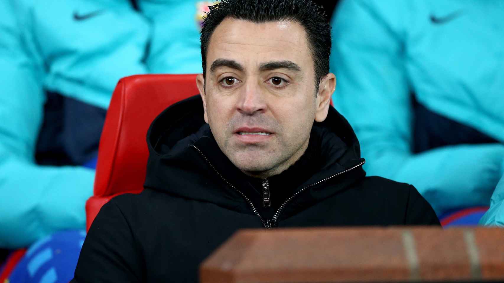 Xavi Hernández sentado en el banquillo de Old Trafford