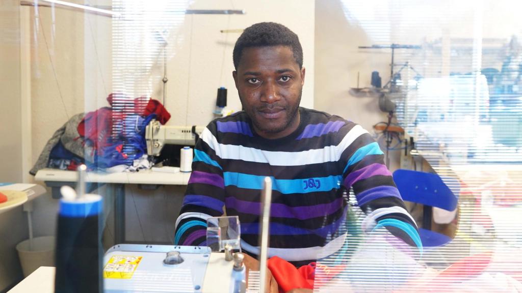 Alhassane Diallo, joven de Guinea-Conakry, posa con su máquina de coser