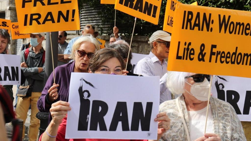 Varias personas con carteles participan en una concentración frente a la embajada de Irán en Madrid.