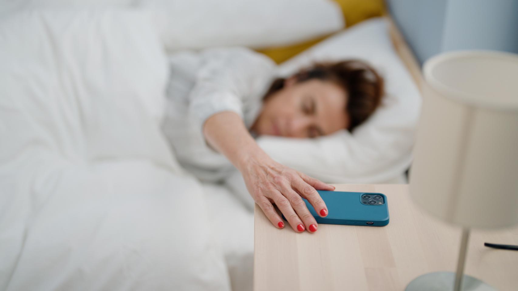 Imagen de archivo de una mujer apagando el despertador.