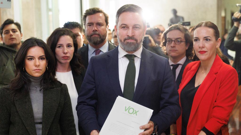 Santiago Abascal, rodeado de dirigentes de Vox, muestra el escrito de la moción de censura registrado este lunes en el Congreso.