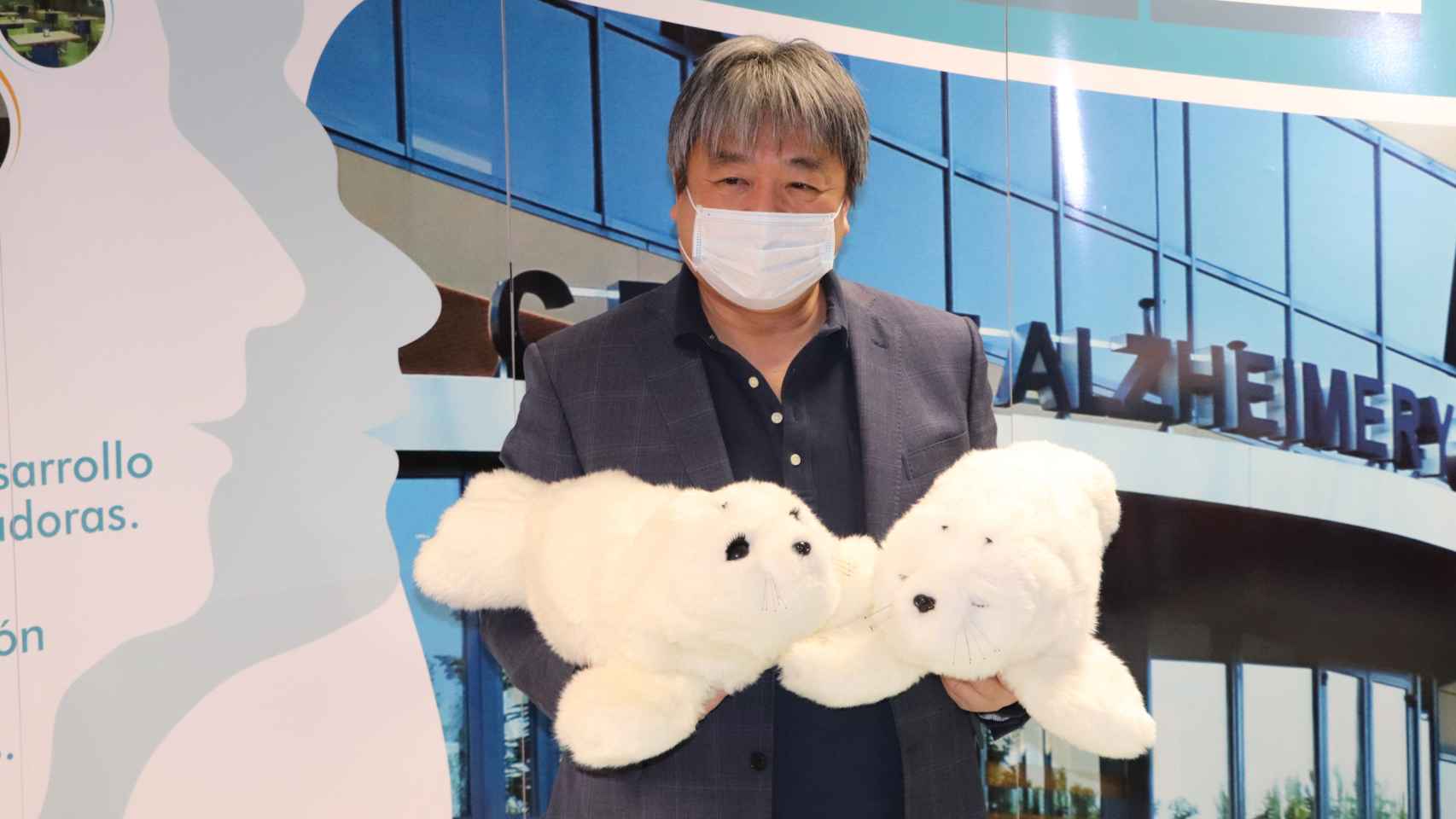 Takanori Shibata presenta dos focas-robot PARO en la puerta del CRE Alzheimer