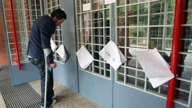 Un joven busca su mesa en el censo electoral en un colegio de Valladolid en la jornada de elecciones generales