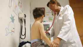 Una pediatra atiende a un niño en su consulta