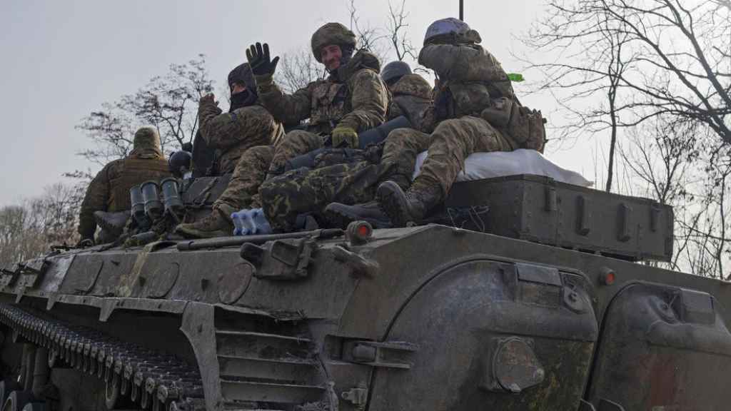 Militares ucranianos encima de un vehículo blindado en una carretera en Bakhmut.