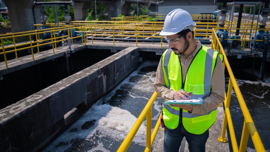 Un ingeniero toma mediciones en una planta de depuración de aguas residuales