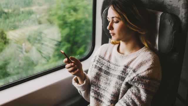 Imagen de archivo de una chica con su móvil en el tren.
