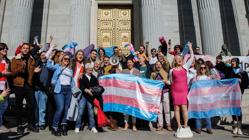 Irene Montero junto a activistas por la Ley Trans junto a la bandera.
