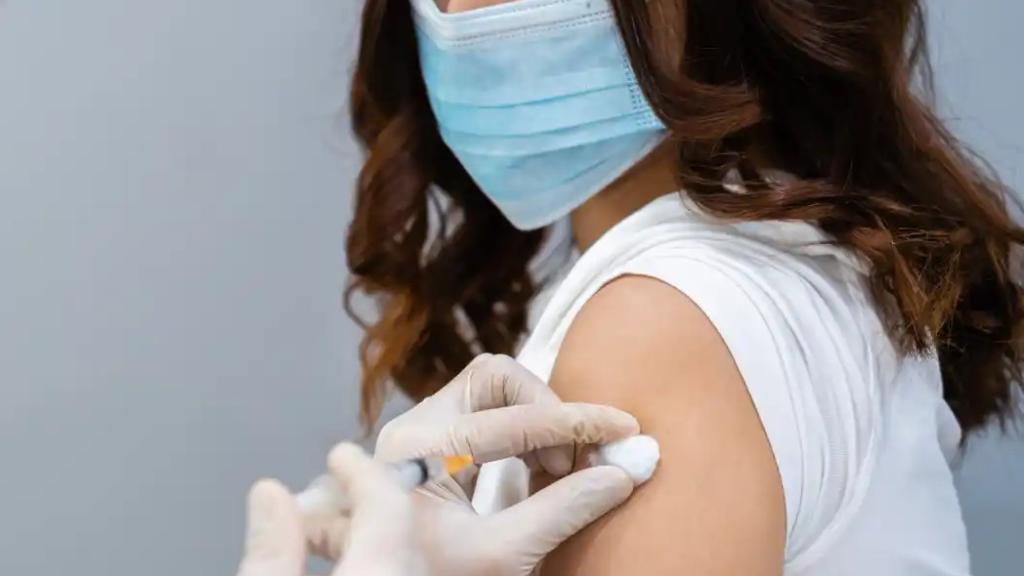 Un sanitario vacuna a una paciente contra el Covid.