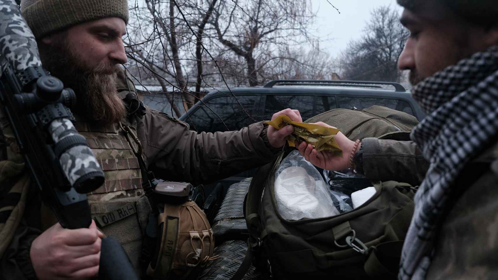 Uno de los francotiradores ayuda al médico a preparar el equipo sanitario para cargarlo en los vehículos.