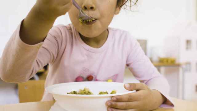 Imagen de archivo de una niña comiendo en el comedor escolar. Pere Gibert/Educo EP