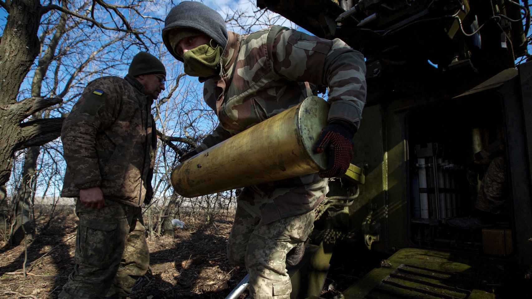 Un militar ucraniano lleva un proyectil para un obús 2S5 Giatsint-S antes de disparar contra las tropas rusas fuera de la ciudad de primera línea de Bakhmut.