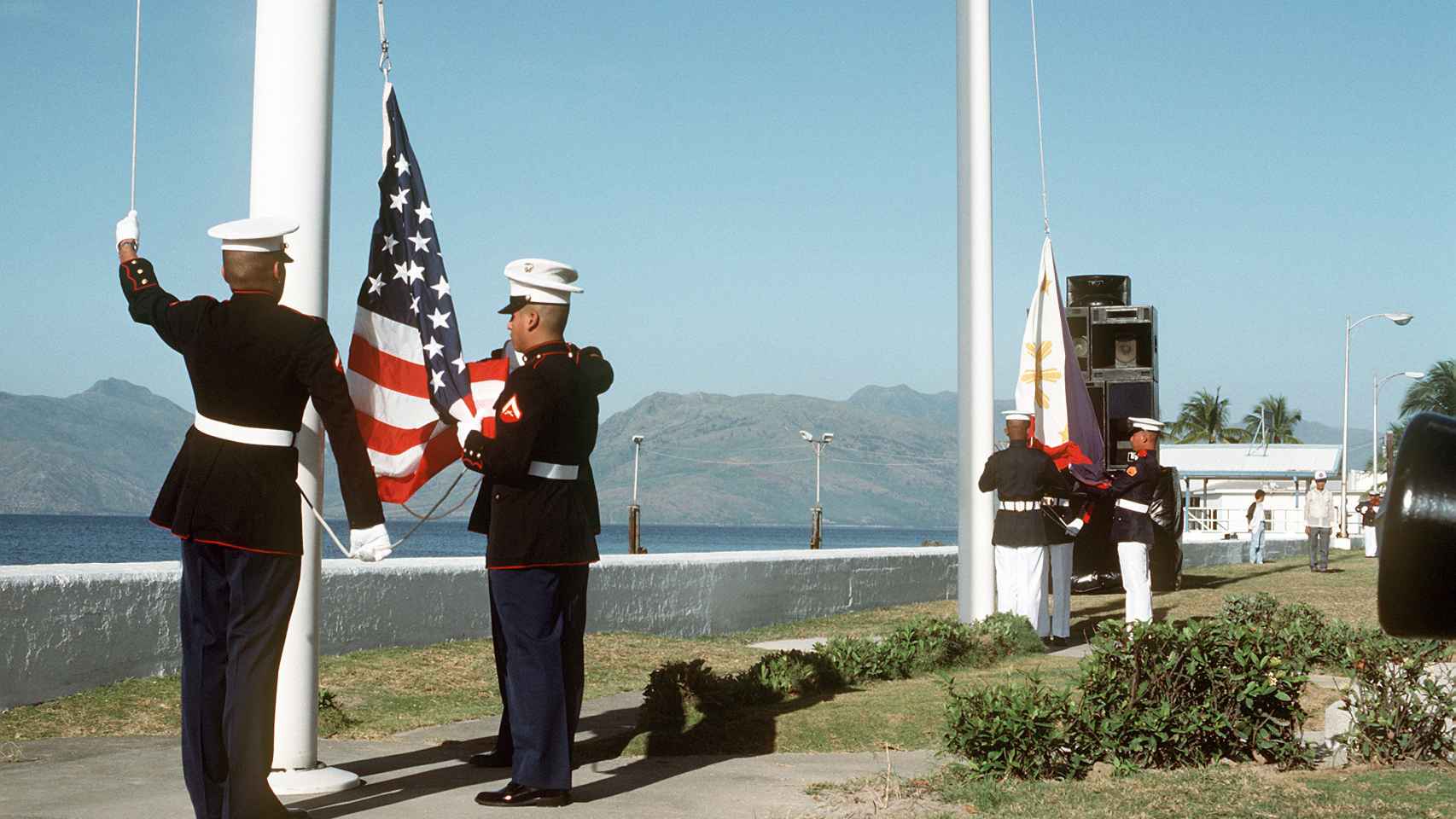 Los infantes de marina estadounidenses levantan la bandera estadounidense mientras sus homólogos filipinos levantan la suya.
