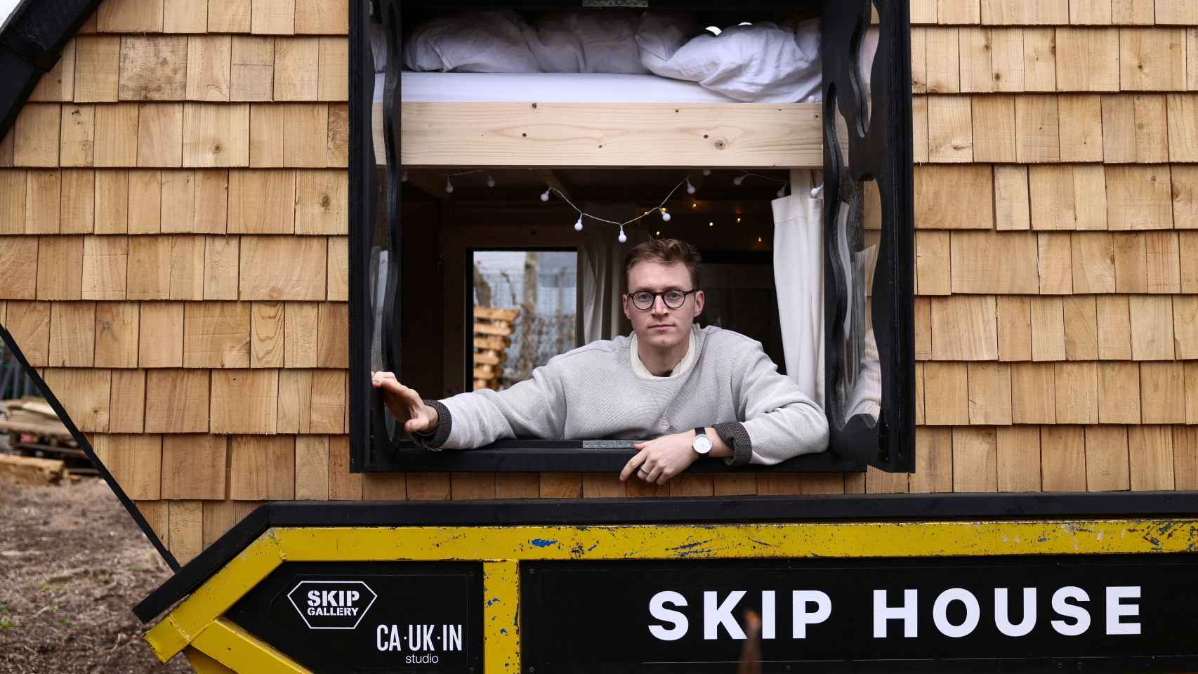 El artista Harrison Marshall posa en el interior del contenedor que ha convertido en vivienda, en la que pretende vivir durante un año.