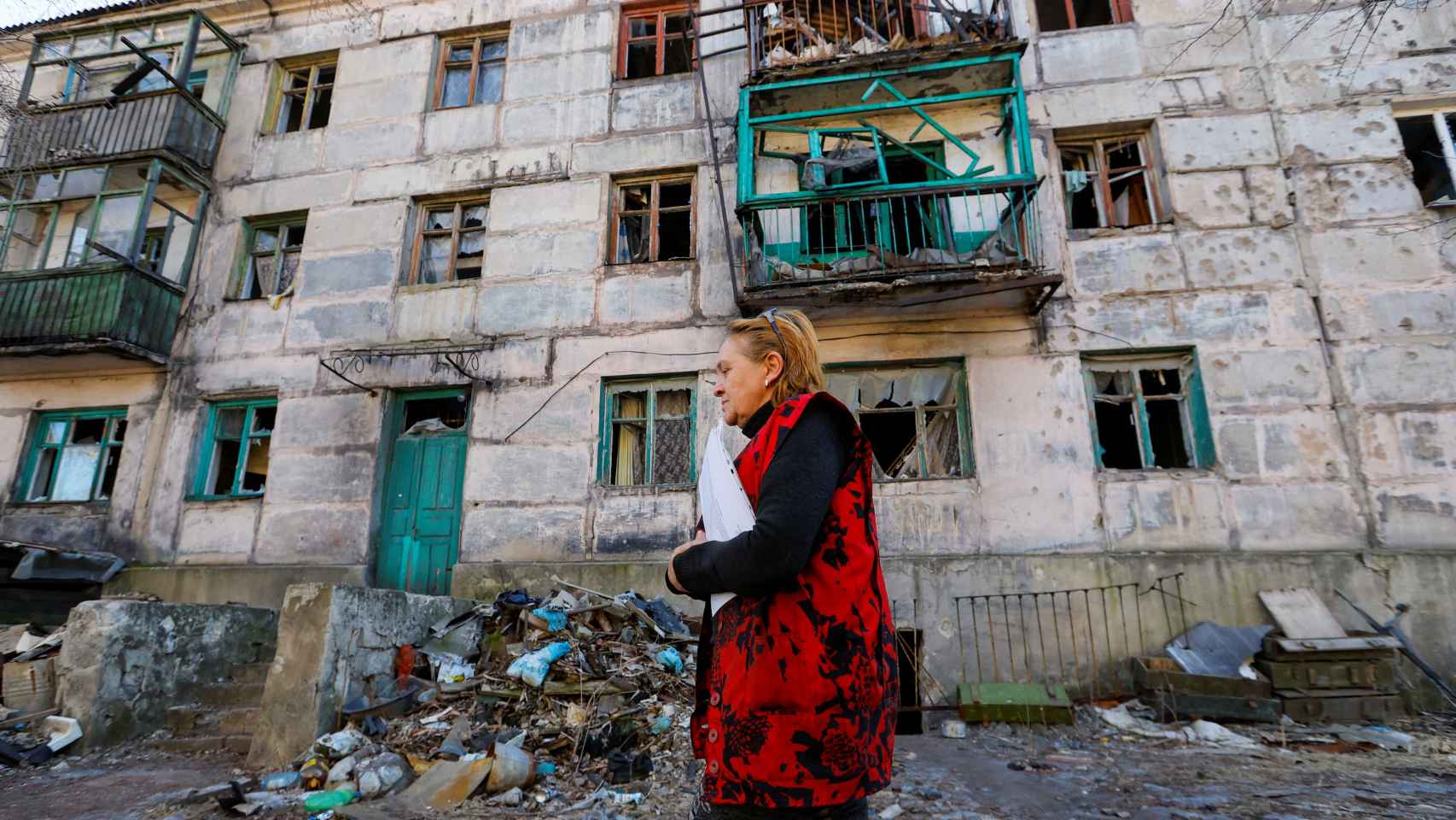Una mujer camina delante de un edificio destruido por bombardeos rusos en la localidad ucraniana de Zolote (Lugansk)