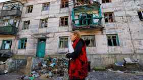 Una mujer camina delante de un edificio destruido por bombardeos rusos en la localidad ucraniana de Zolote (Lugansk)