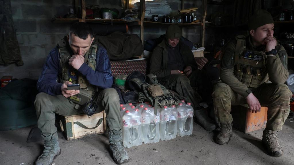Los miembros del servicio ucranianos descansan en una posición después de disparar contra las tropas rusas en las afueras de la ciudad de Bakhmut .