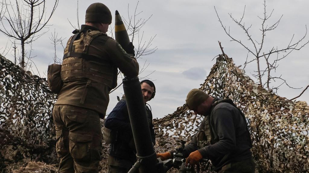 Los miembros del servicio ucranianos cargan un proyectil en un mortero antes de disparar contra las tropas rusas en las afueras de la ciudad de Bakhmut .