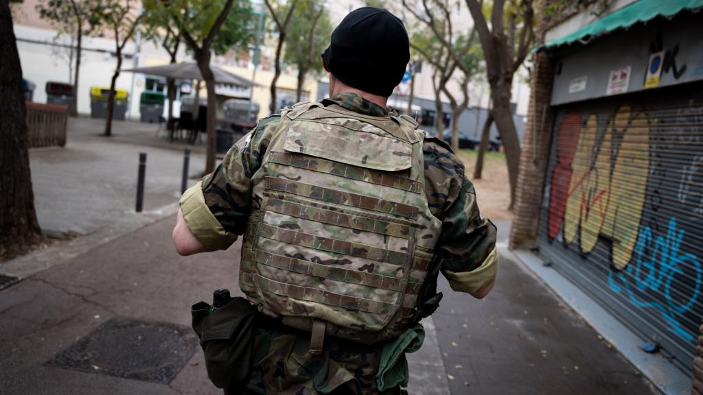 Juan Astray, de espaldas, portando un chaleco y un uniforme militar
