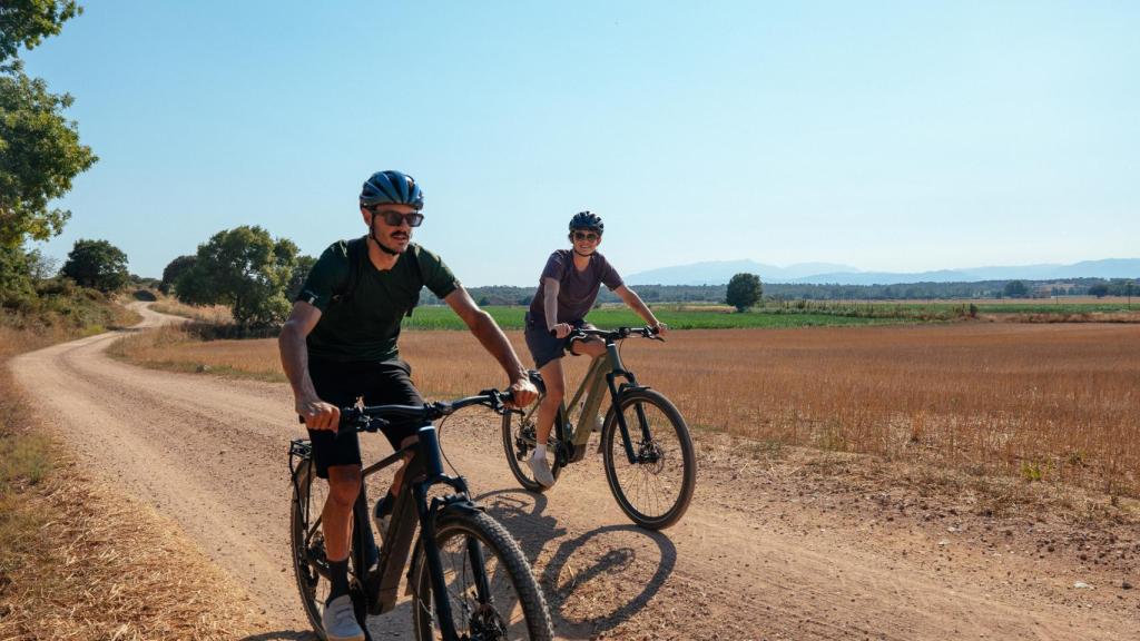 Imagen de archivo de dos jóvenes en bici eléctrica.