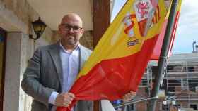 José Luis Labrador posa con la bandera de España en el Ayuntamiento de Manzanares El Real.