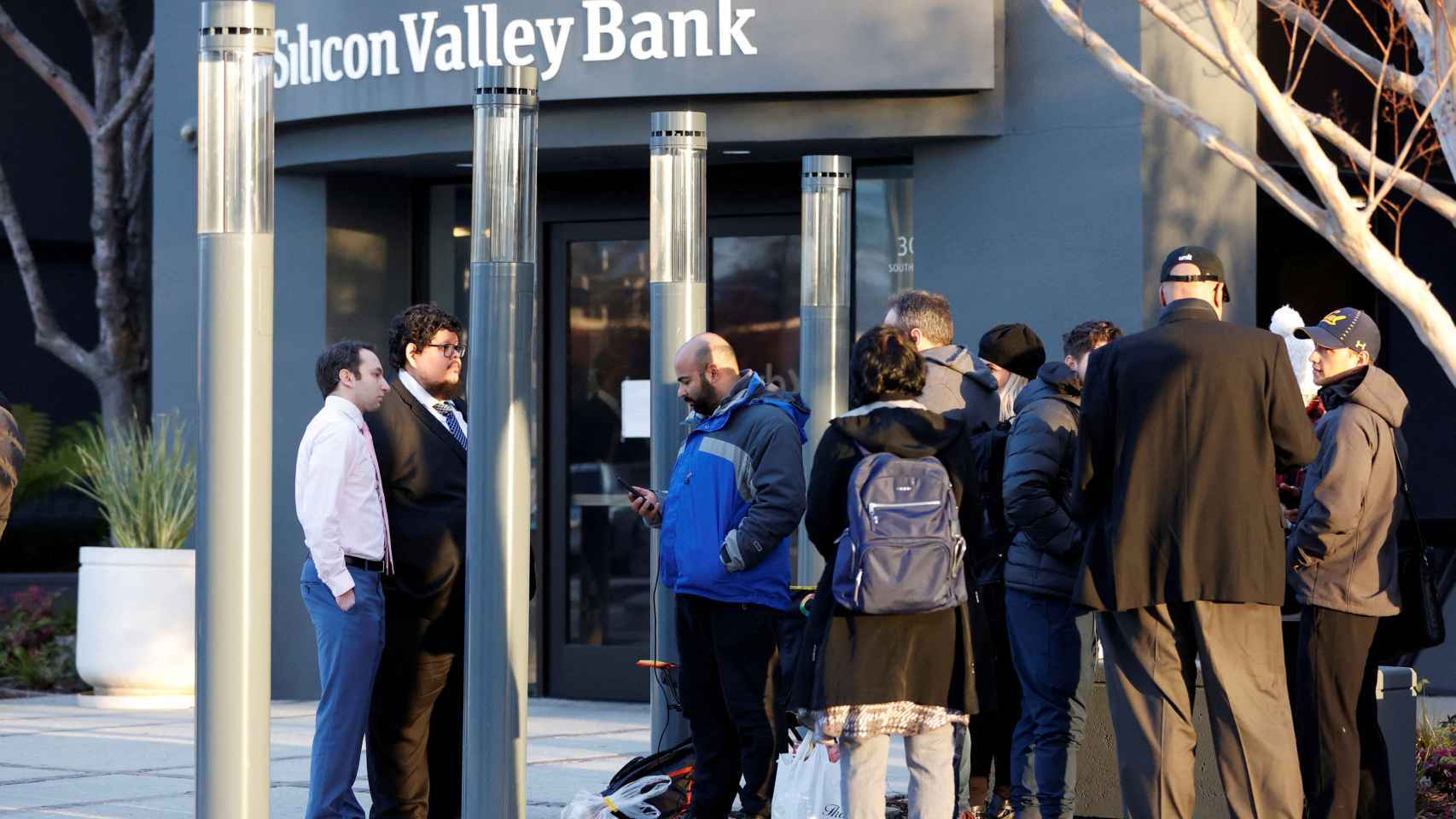 Dos representantes del FDIC habla con varios clientes de Silicon Valley Bank en el exterior de la sede de la entidad en Santa Clara, California (EEUU).