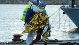 Un migrante rescatado de un naufragio en el Mediterráneo asistido por un miembro de la Cruz Roja a su llegada al puerto siciliano de Pozzallo.