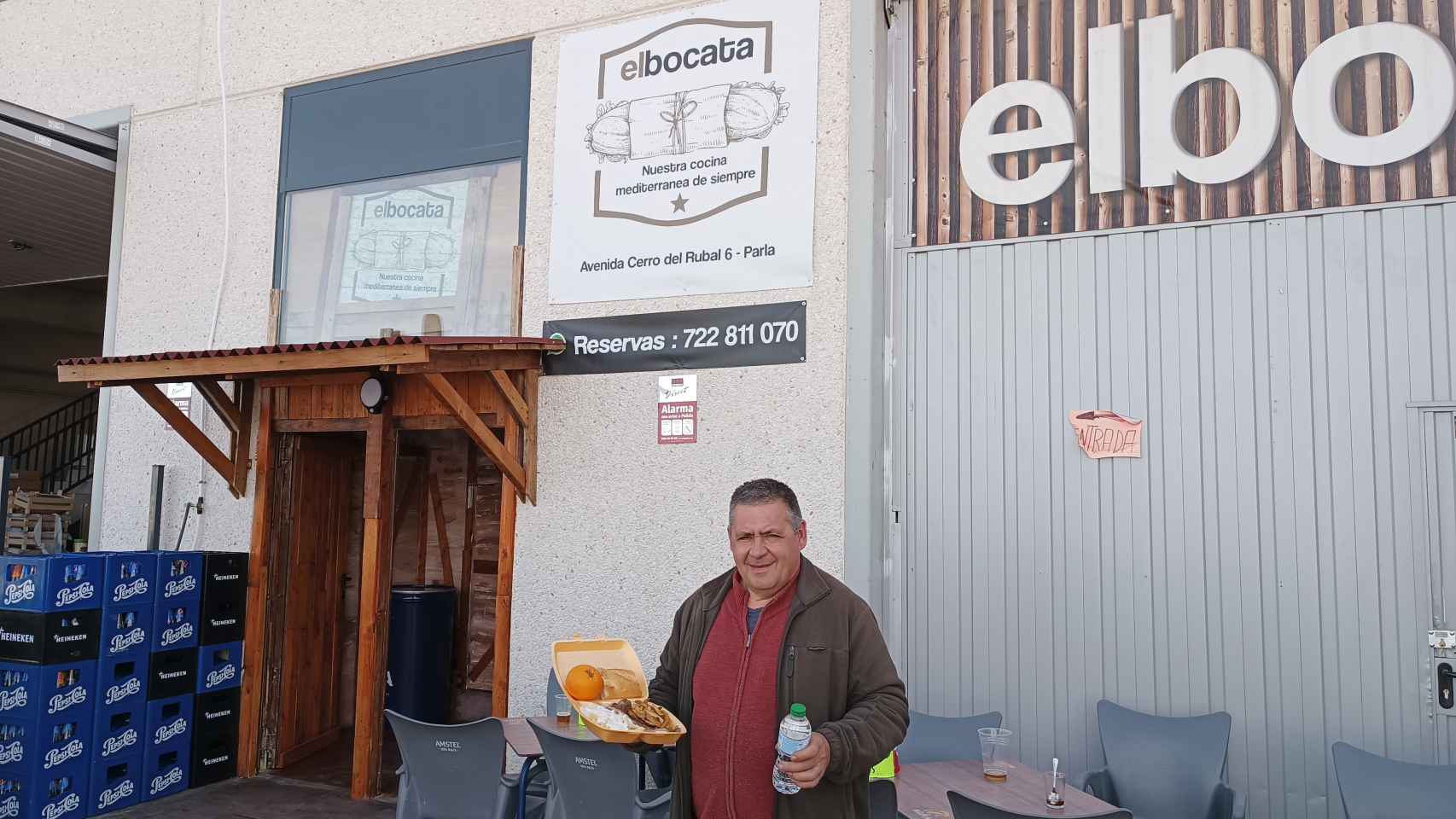 Carlos Moreno, dueño de El Bocata, sostiene un menú del día para llevar.