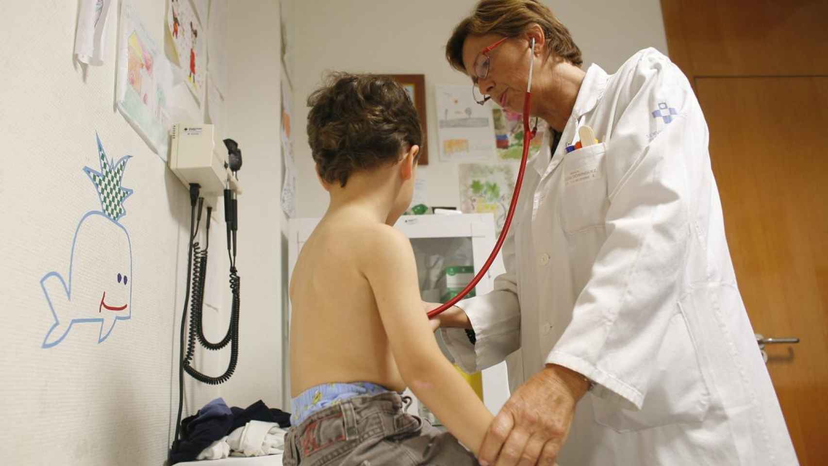 Una pediatra pasa consulta a un niño.