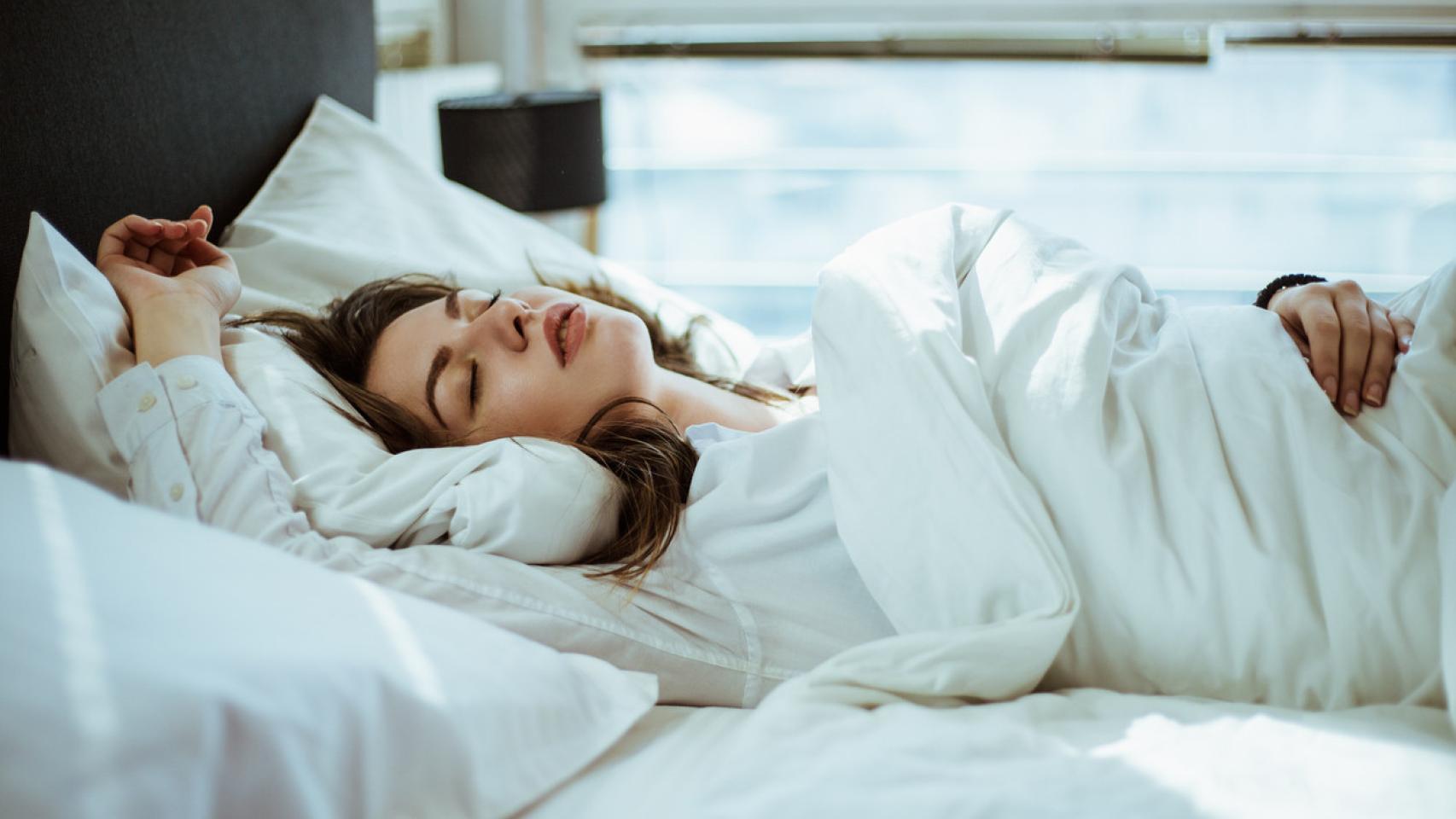 Una mujer duerme arropada.