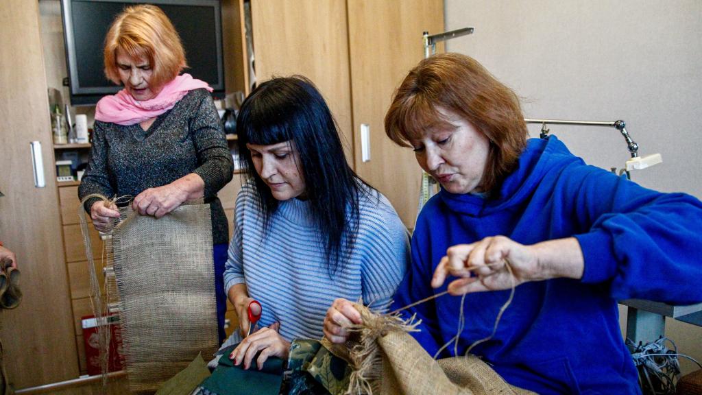 De izquierda a derecha) Liubov Shyshliova, Julia Julaeva y Alina Duzhko trabajan en la confección de trajes de camuflaje para los francotiradores ucranianos en Kiev, Ucrania.