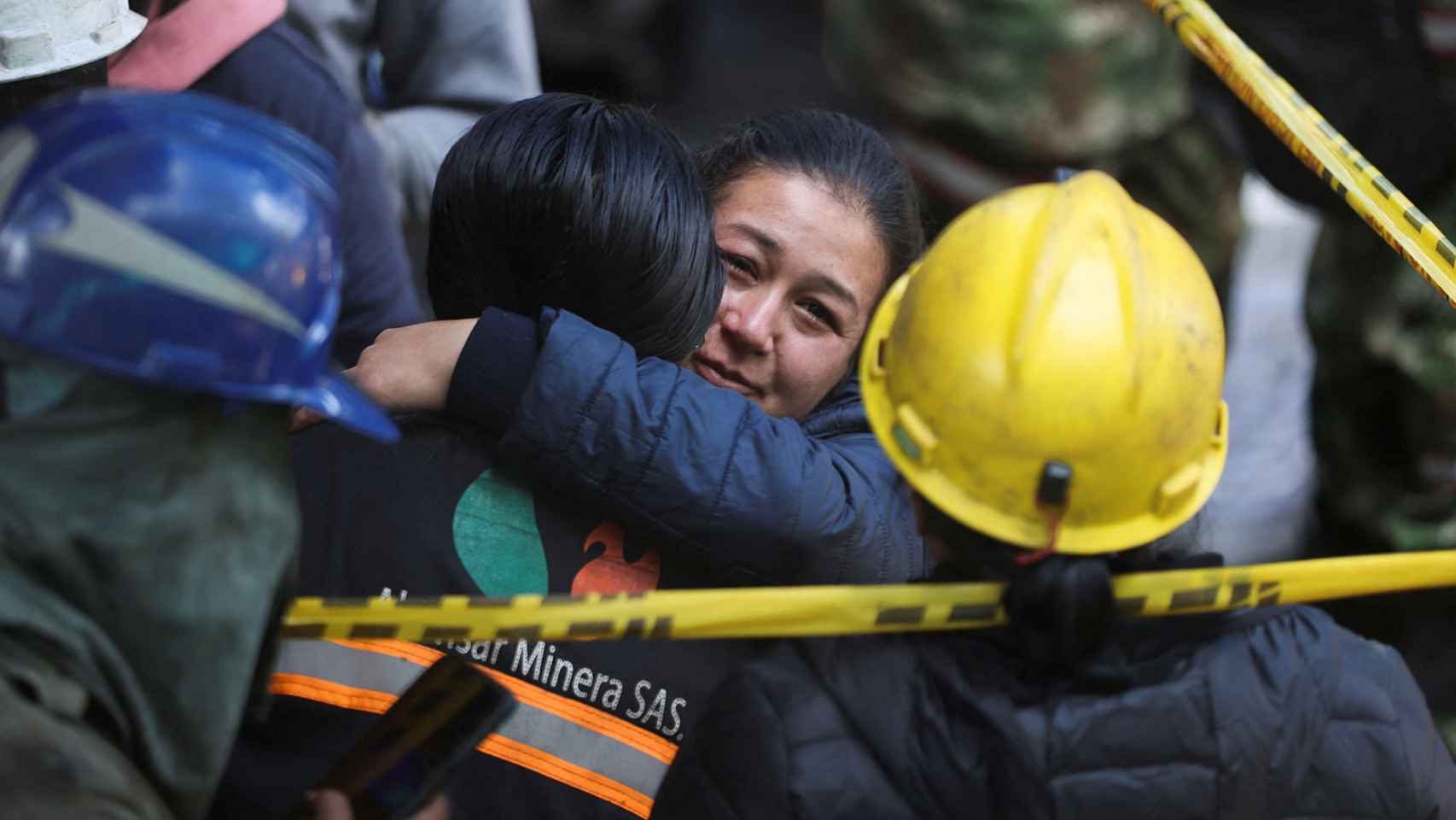 Una mujer se abraza a un miembro del personal de rescate fuera de la mina.