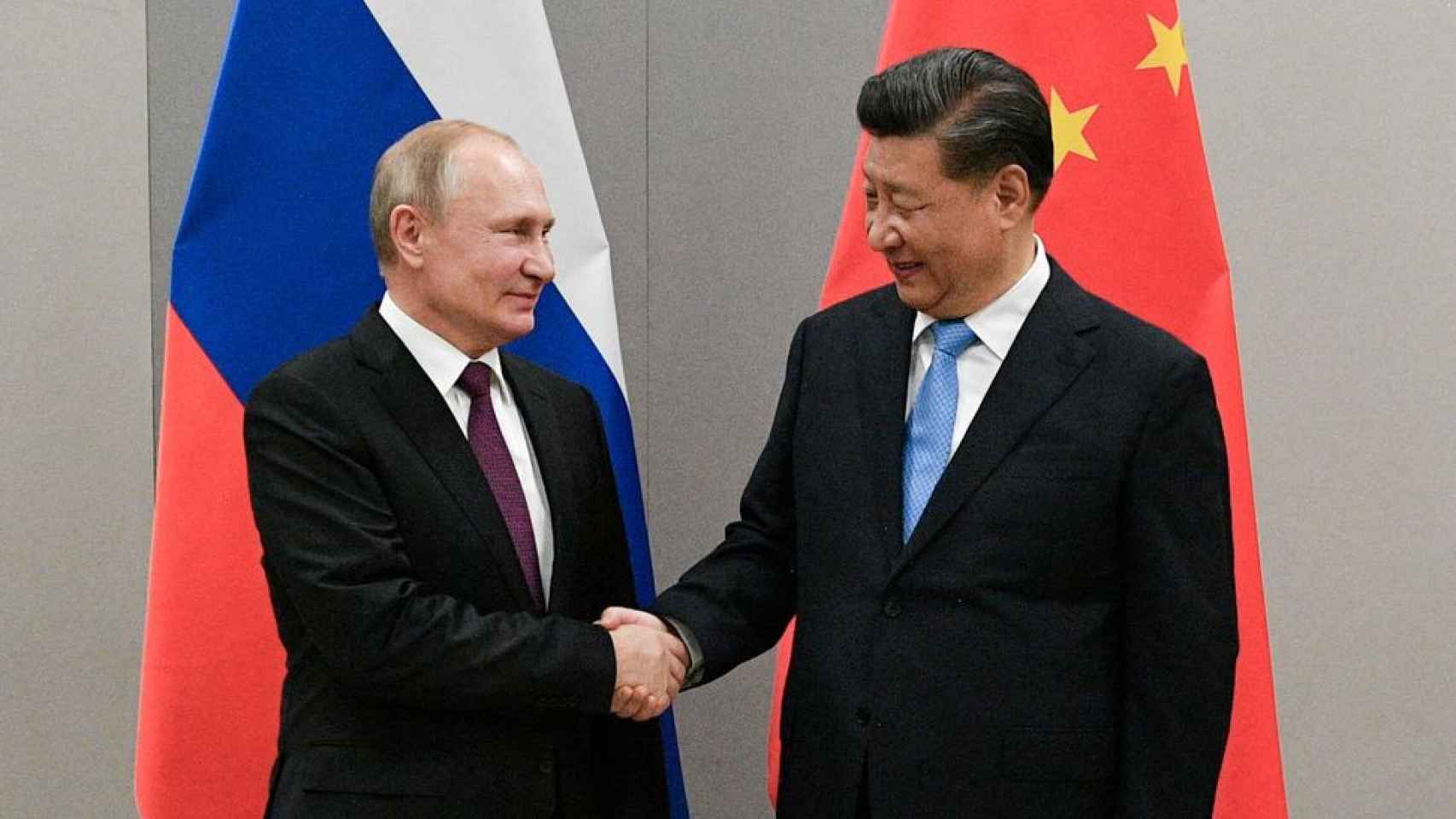 Vladimir Putin y Xi Jinping se dan la mano durante una reunión antes de la pandemia.
