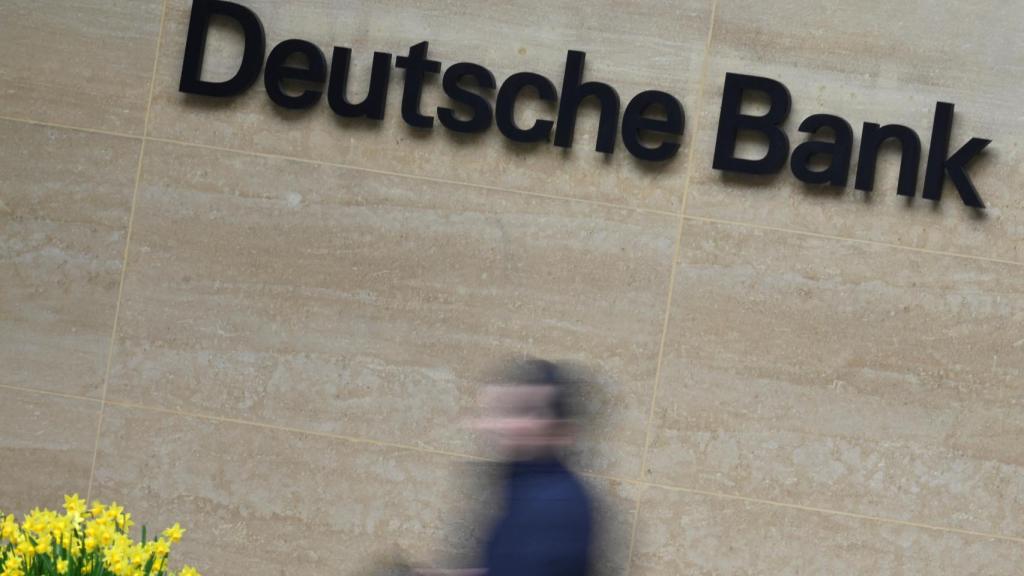 Un trabajador delante del cartel de la sede de Deutsche Bank en Londres.