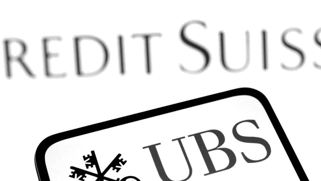 Logo de UBS en la pantalla de un móvil delante del de Credit Suisse.