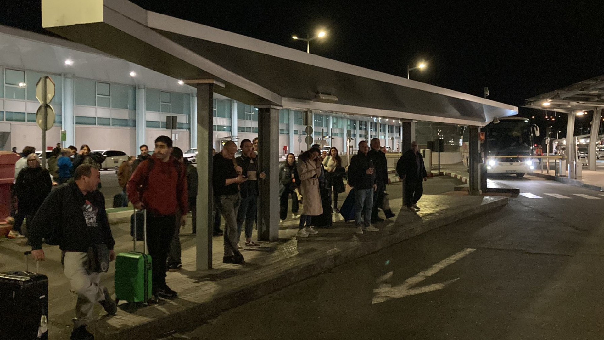 Pasajeros en el exterior del aeropuerto de Peinador esperando al autobús que los llevará al Rosalía de Castro. Fotos: Cedidas