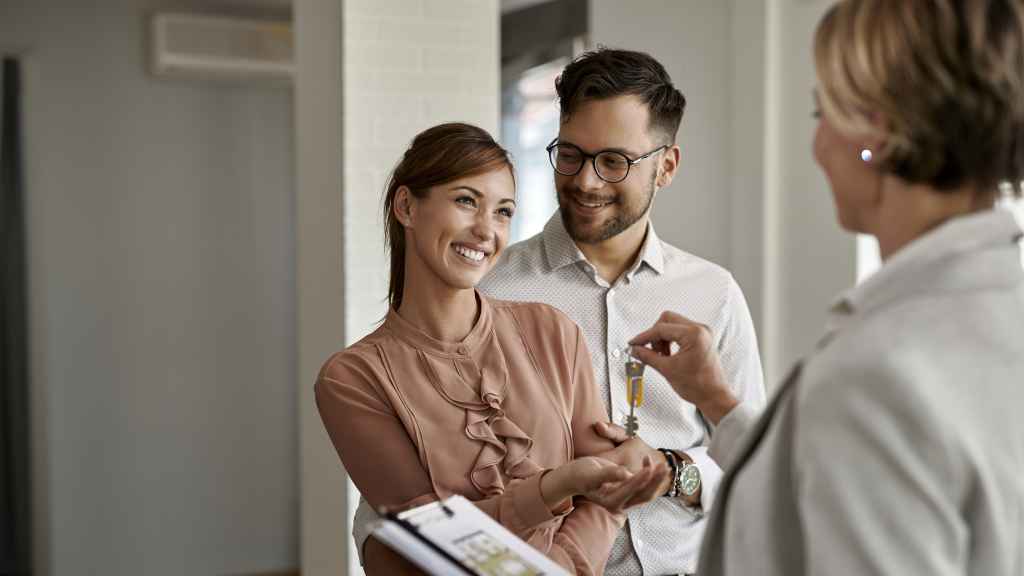 Una pareja recibe las llaves de su nueva casa.