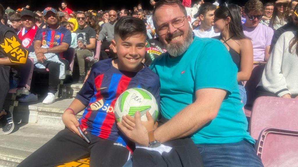 Padre e hijo con la pelota firmada.